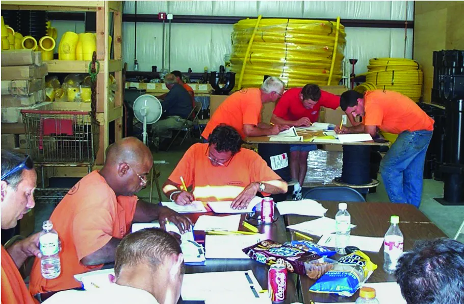 2001 employees doing paperwork at tables with snacks