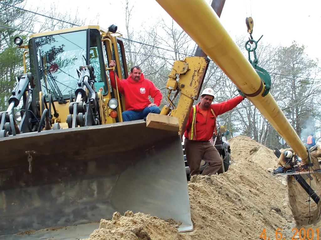 2002 workers placing pipe, using bulldozer