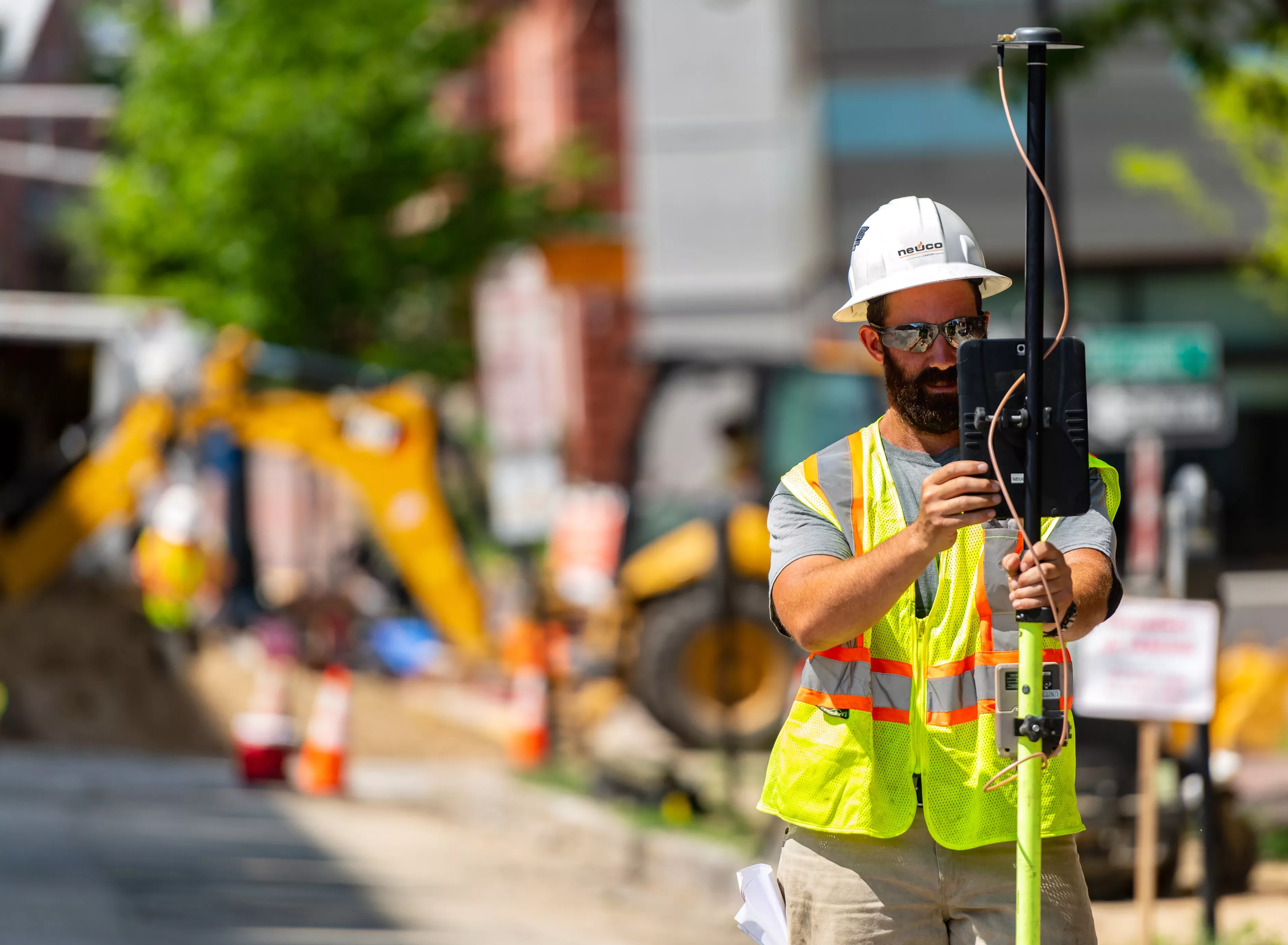 Man in hard hat using surveying equipment
