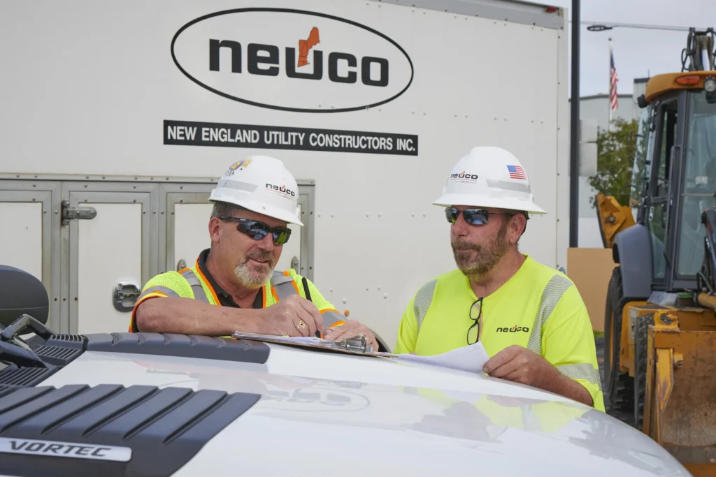 Neuco workers planning on hood of truck
