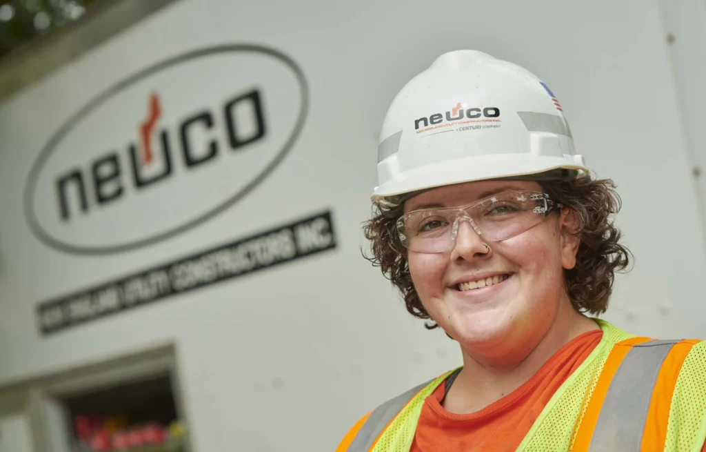 Smiling employee in hard hat and safety glasses